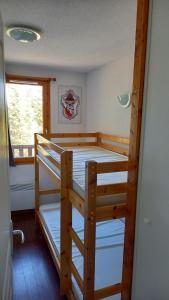 a bedroom with two bunk beds and a window at superbesse Appartement 4-6 pers. 2 ch. Dans résidence 3 étoile avec piscine in Besse-et-Saint-Anastaise