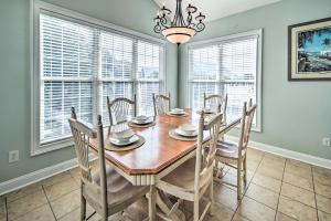 a dining room with a table and chairs and windows at 1 Mi to Beach and Hot Tub Murrells Inlet Retreat! in Myrtle Beach