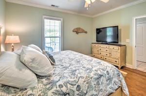 a bedroom with a bed and a flat screen tv at 1 Mi to Beach and Hot Tub Murrells Inlet Retreat! in Myrtle Beach