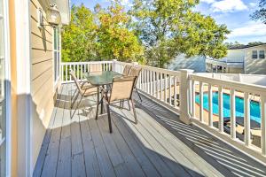 a balcony with a table and chairs and a pool at 1 Mi to Beach and Hot Tub Murrells Inlet Retreat! in Myrtle Beach