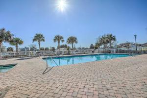 a swimming pool at a resort with palm trees at 1 Mi to Beach and Hot Tub Murrells Inlet Retreat! in Myrtle Beach