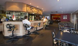 a man sitting at a bar in a restaurant at James Street Motor Inn in Toowoomba