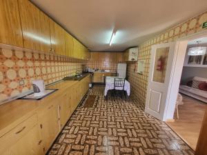 a kitchen with wooden cabinets and a table in it at CASA RIBEIRINHO No Coração da Natureza in Pedregal