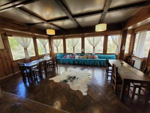 a living room with a blue couch and tables and chairs at Posada del Ñireco in San Carlos de Bariloche