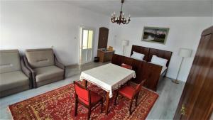 sala de estar con mesa, sillas y sofá en Casa Sommer, en Petreşti
