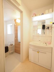 a white bathroom with a sink and a mirror at La Lumiere Oroku / Vacation STAY 1068 in Naha