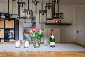 Una mesa con una botella de champán y flores. en Haus Panorama en Niedersalwey