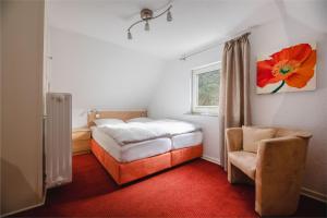 NiedersalweyにあるHaus Panoramaのベッドルーム1室(ベッド1台、椅子、窓付)
