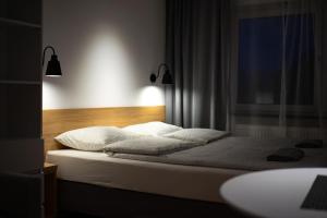 uma cama com almofadas brancas e uma janela num quarto em Pokoje w centrum em Krościenko