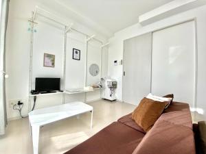 uma sala de estar com um sofá e uma mesa em La Lumiere Oroku / Vacation STAY 1051 em Naha