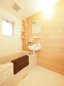 uma casa de banho com um lavatório e uma banheira em La Lumiere Oroku / Vacation STAY 1051 em Naha