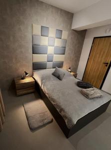a bedroom with a large bed with a headboard at Premium Apartment Eleven in Zator