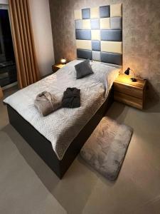 a bedroom with a large bed with a black shirt on it at Premium Apartment Eleven in Zator