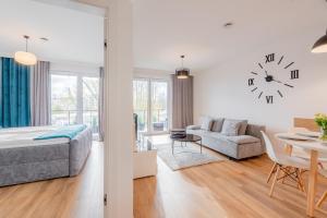 ein Schlafzimmer mit einem Bett und einer Uhr an der Wand in der Unterkunft Apartament Wyspa Solna Kołobrzeg in Kołobrzeg + 13 Fotos