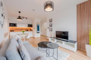 ein Wohnzimmer mit Couch und Tisch in der Unterkunft Apartament Wyspa Solna Kołobrzeg in Kołobrzeg
