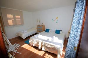 a bedroom with two beds and a table and a chair at El Rincón, peace at the sea, with jacuzzi in Cala Ratjada