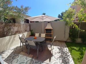 a patio with a table and chairs and an umbrella at El Rincón, peace at the sea, with jacuzzi in Cala Ratjada