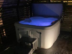a hot tub with a bluevisor sitting on a porch at Peacock Lake Glamping in Nottingham