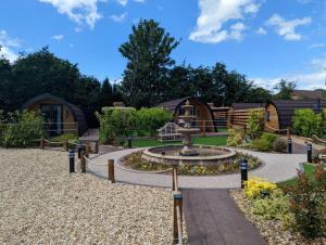 a garden with a fountain in the middle at Peacock Lake Glamping in Nottingham