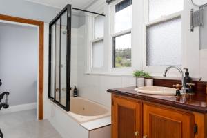 a bathroom with a tub and a sink and a shower at The Dragonfly Inn in Launceston +53 photos