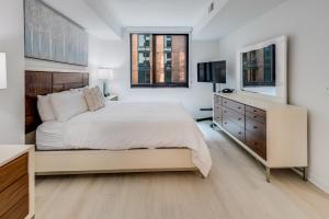 a white bedroom with a large bed and a dresser at Global Luxury Suites at Capitol Hill in Washington, D.C.