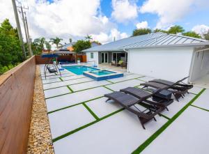 um pátio com espreguiçadeiras e uma piscina em Miami Family Home 5BR Heated Pool & Jacuzzi L45 em Tamiami