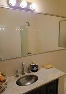 a bathroom with a sink and a large mirror at La Casa de la Puerta Azul in Mendoza