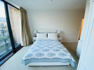 a bedroom with a bed and a large window at Spacious two Bedroom Apartment in Balham in London