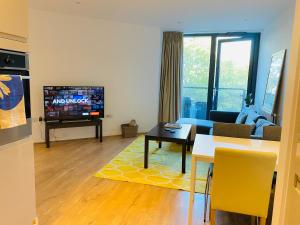 ein Wohnzimmer mit einem Sofa und einem TV in der Unterkunft Spacious two Bedroom Apartment in Balham in London