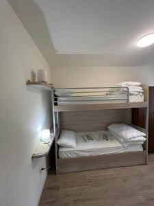 een slaapkamer met 2 stapelbedden in een kamer bij Ca' Domani - Appartamento immerso nel Cadore in Domegge di Cadore