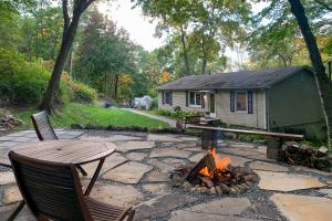 a fire pit with a wooden table and a chair and a table and a fire at Peaceful Home with Deck Family and Pet Friendly! in Ringwood