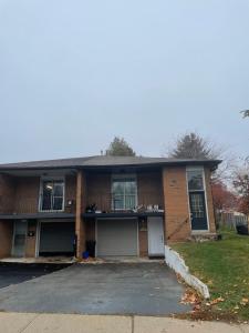 a brick house with a balcony and a driveway at Stunning & cozy freshly renovated 2 bedroom basement unit in Kitchener