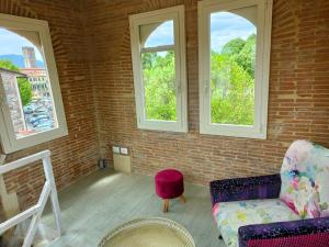 a living room with a couch and two windows at Inside the Wall in Lucca