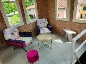2 Stühle und ein Tisch auf einer Veranda in der Unterkunft Inside the Wall in Lucca