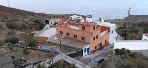 ein großes orangefarbenes und weißes Haus am Meer in der Unterkunft Vivienda Vacacional Sabinosa in Sabinosa