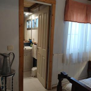 un baño con una puerta que conduce a un lavabo en Casa Rural Abuela Simona, en Vega de Santa María