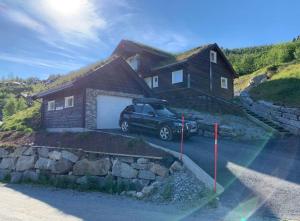 a car parked in front of a house at Fjelltun Lodge in Sogndal