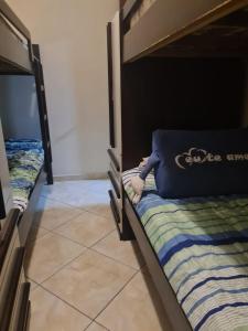 - 2 lits superposés dans une chambre avec un oreiller sur le lit dans l'établissement Apto a 50m da praia, com ar condicionado, wifi , portaria 24h, à Praia Grande