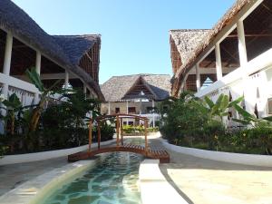 a pool in the courtyard of a resort at Paka House-Rafiki Village in Watamu