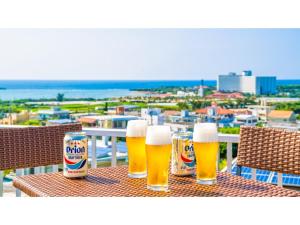 a table with three glasses of beer and a can of soda at Hotel Sunset Zanpa - Vacation STAY 50194v in Tokeshi