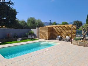 a swimming pool with two chairs and a fence at Belle villa avec piscine vue montagne à 10 mn de la mer à Argeles in Argelès-sur-Mer