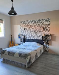 ein Schlafzimmer mit einem Bett mit einer Steinmauer in der Unterkunft Belle villa avec piscine vue montagne à 10 mn de la mer à Argeles in Argelès-sur-Mer