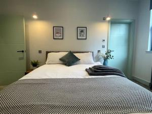 a bedroom with a large white bed with two pillows at Cute 1-Bedroom Ground Apartment in Stoke Newington in London