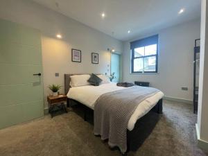 a bedroom with a large bed and a window at Cute 1-Bedroom Ground Apartment in Stoke Newington in London