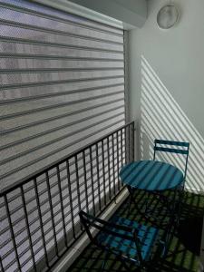 una silla azul y una mesa en el balcón en Appartement moderne, 2 chambres, proche aéroport • CHU • port en Les Abymes