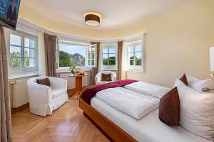 a bedroom with a bed and a table and windows at Laasenhof Resort in Struppen
