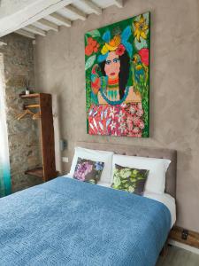 a bedroom with a blue bed and a painting on the wall at Inside the Wall in Lucca