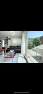 a living room with a couch and a large window at La villa petite Camargue in Saint-Louis