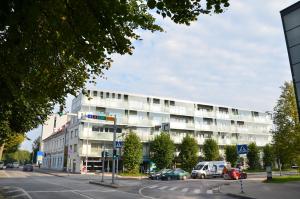 um edifício branco com carros estacionados em frente em Raatuse Apartment em Tartu