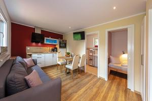 a living room with a couch and a kitchen at Laasenhof Resort in Struppen